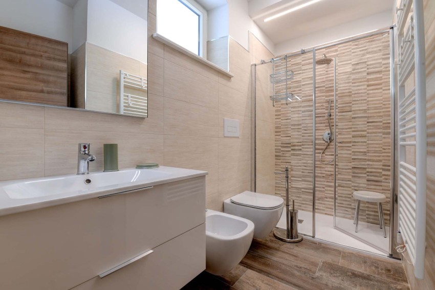 Bagno moderno con doccia in vetro, bidet e lavabo vicino al Lago di Garda