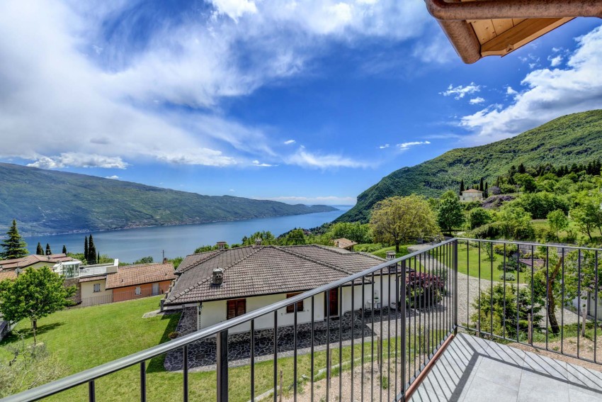 Balkonblick über den Gardasee mit Häusern und grünen Hügeln
