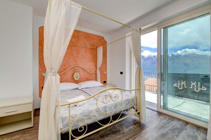 Bedroom with canopy bed and balcony, Lake Garda and mountain view