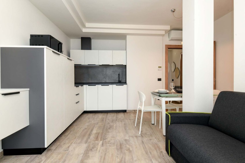 Cucina moderna con tavolo apparecchiato e divano, vicino al Lago di Garda