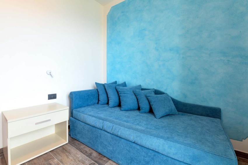 Divano letto blu con cuscini in camera luminosa vicino al lago di garda