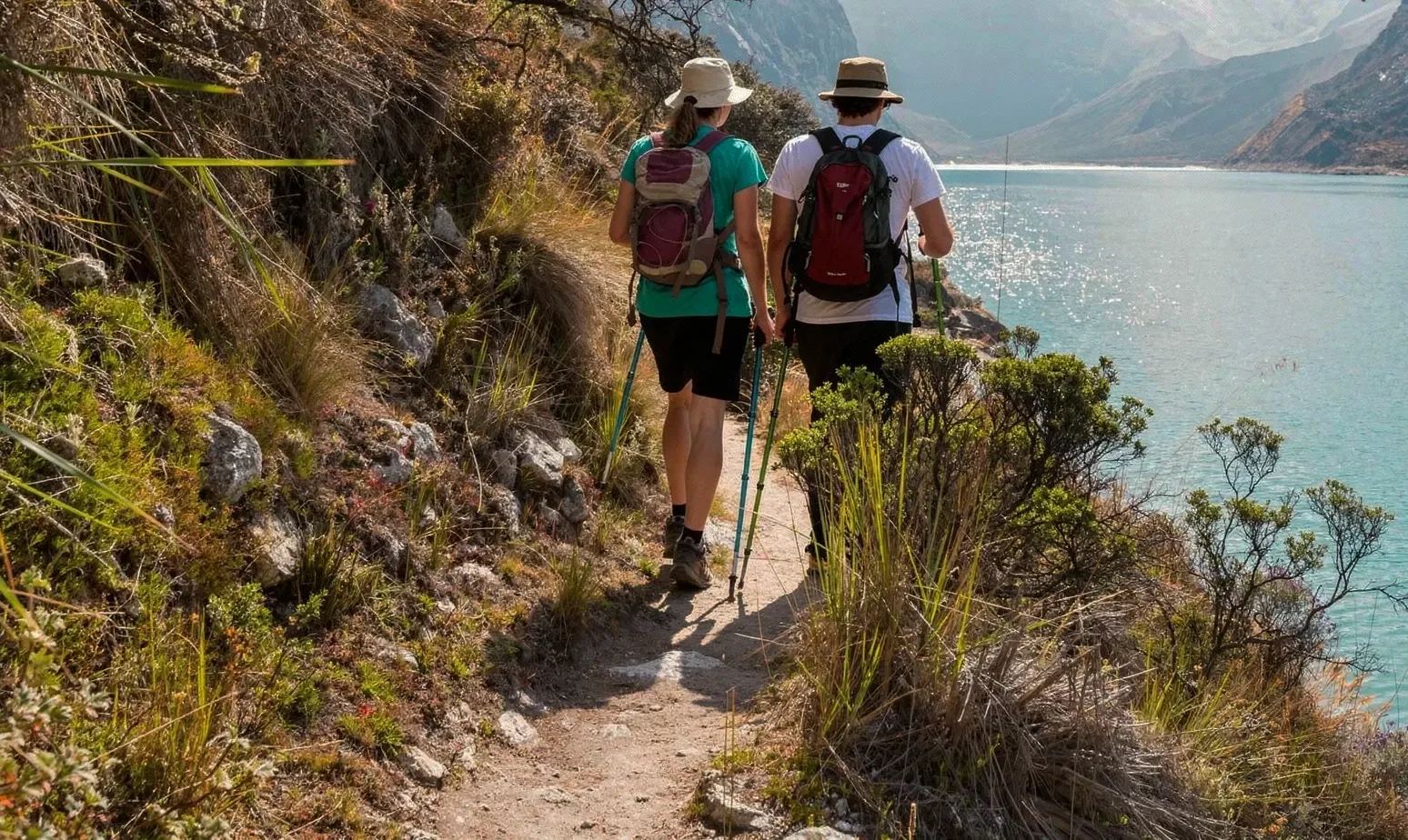 Hikers on a lakeside mountain trail at Lake Garda, with trekking poles and backpacks