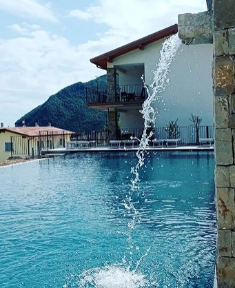 Infinity pool with waterfall and mountain view near Lago di Garda