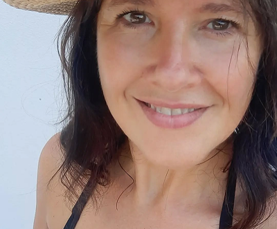 Lachende Person mit Strohhut am Lago di Garda, sommerliches Porträt.