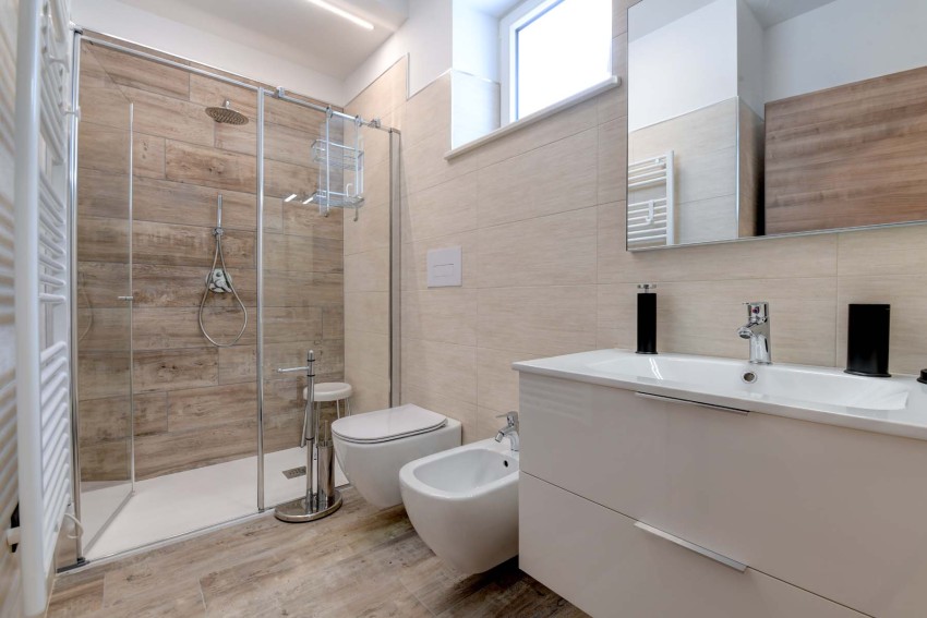 Modern bathroom with glass shower, bidet and vanity near Lake Garda