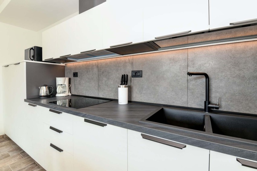 Modern kitchen with gray countertop, black sink, kettle and coffee maker, Lake Garda