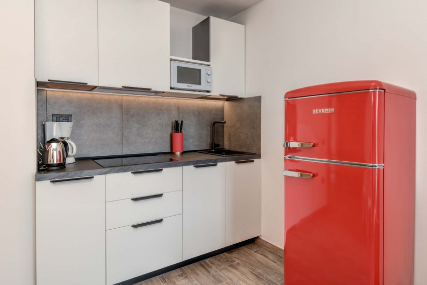Modern compact kitchenette with red retro fridge, near Lago di Garda