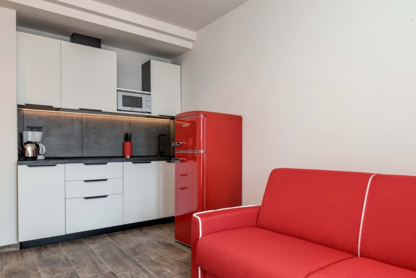 Moderne Küchenzeile mit rotem Kühlschrank und Sofa am Lago di Garda