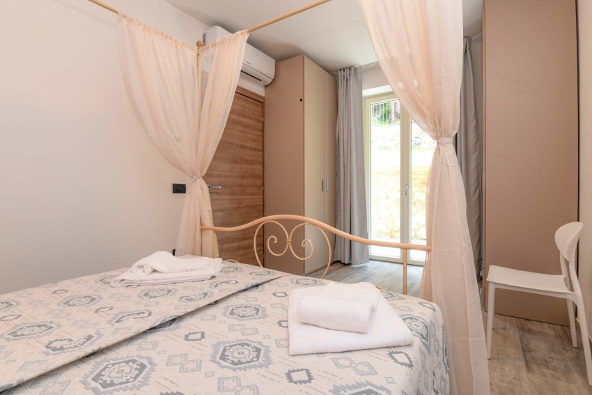 Gemütliches Schlafzimmer mit Himmelbett und Handtüchern, nahe Lago di Garda